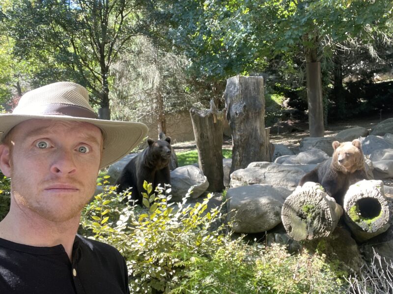 Man standing in front of two bears with a scared look on his face